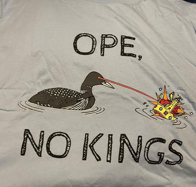 A t-shirt with an image of a loon shooting a laser at a crown.  The text reads “ope, no kings”

Because - No Kings for America.