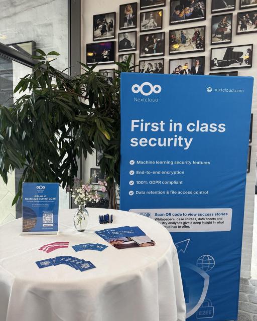 Photo from Nextcloud Enterprise Day Copenhagen: Tall Nextcloud banner and a table with various collateral material