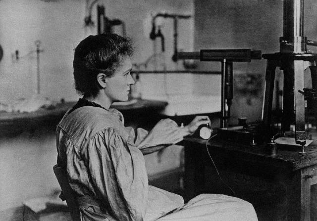 Marie Curie in her laboratory

The measurement of radioactivity requires great dexterity and inventive spirit. It was made possible with an experimental advice conceived by Pierre Curie, which makes it possible to measure very small charges.

The image shows Curie in profile, facing left, seated at a wooden laboratory table.

She wears a simple, long-sleeved laboratory gown, gathered at the shoulders and waist .

Her posture is upright and attentive; one hand gently adjusts a control dial, while the other rests near a piece of scientific equipment.

https://commons.wikimedia.org/wiki/Maria_Sk%C5%82odowska-Curie?uselang=fr#/media/File:Marie_Curie_in_her_laboratory.jpg