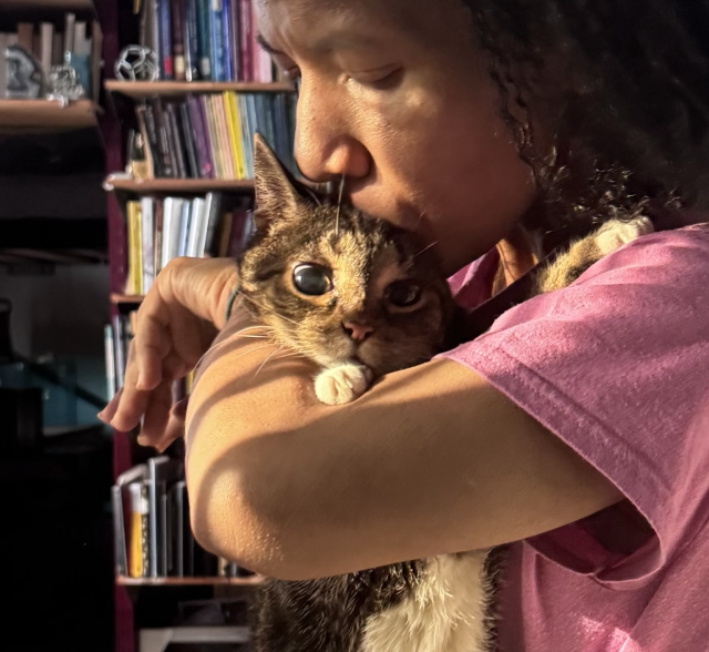 Pico with eyes wide in the sunlight, realizing she can’t avoid the kiss