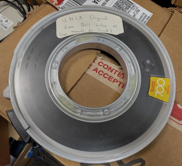 An old reel to reel magnetic tape. It has a label, in Jay Lepreau's handwriting, proclaiming it to be "UNIX Original from Bell Labs v4 (see manual for fmt)"