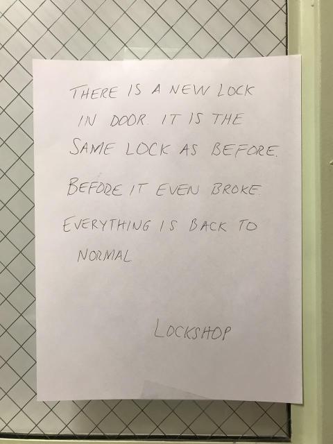 A hand-written note on typical white office paper. It is in all-caps, in pencil, and the punctuation is drawn in very lightly so it kind of looks like all one sentence running together. It says: “There is a new lock in door. It is the same lock as before. Before it even broke. Everything is back to normal.”
The note is signed as “Lockeshop”