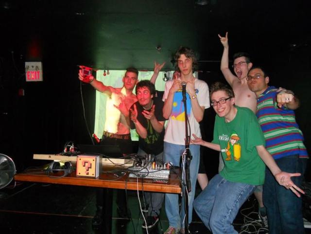 A group of young people posing wildly on a stage.