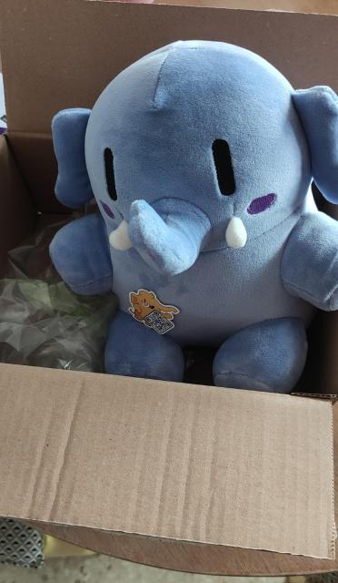 Un peluche de la mascota de Mastodon que, a parte de ser blandito, es azul y está en una cajita.