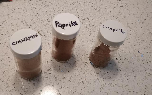 Three spice jars are shown, one is marked cinnamon, one marked paprika, the third is marked "cinaprika."