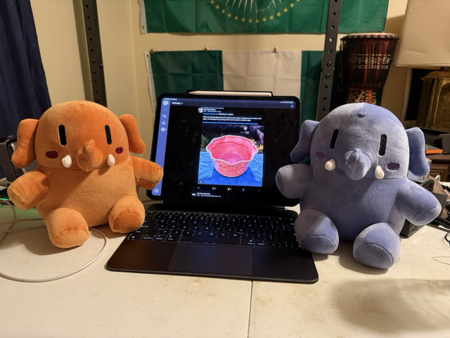 Two smaller plushies next to the iPad Pro in the center. iPad Pro is displaying the Mastodon app.