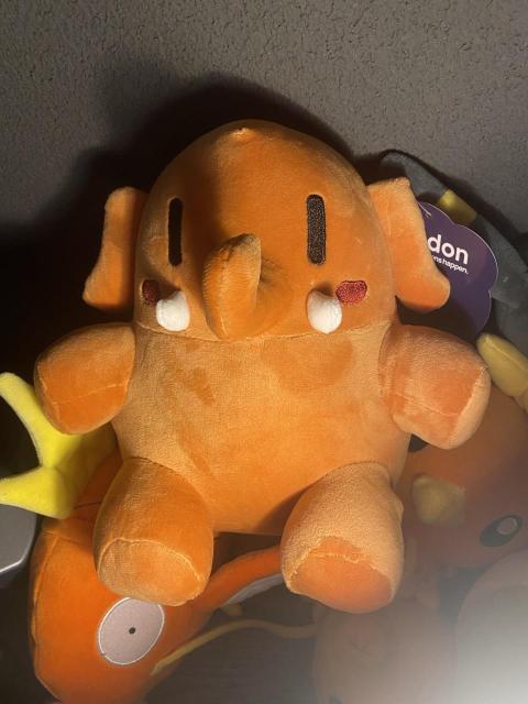 an orange mastodon plushie (the official one!!) on top of my torchic and magikarp plushies