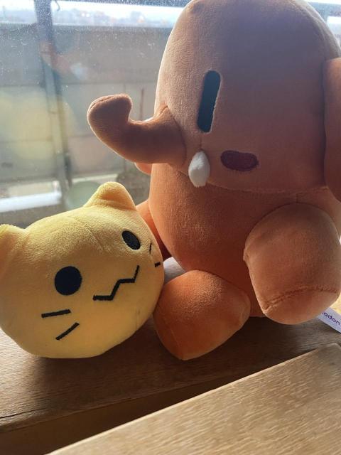 a photo of the orange mastodon plushie and the small yellow blobcat plushie