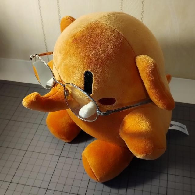 Ein Plüsch-Mastodon-Maskottchen mit Brillen.