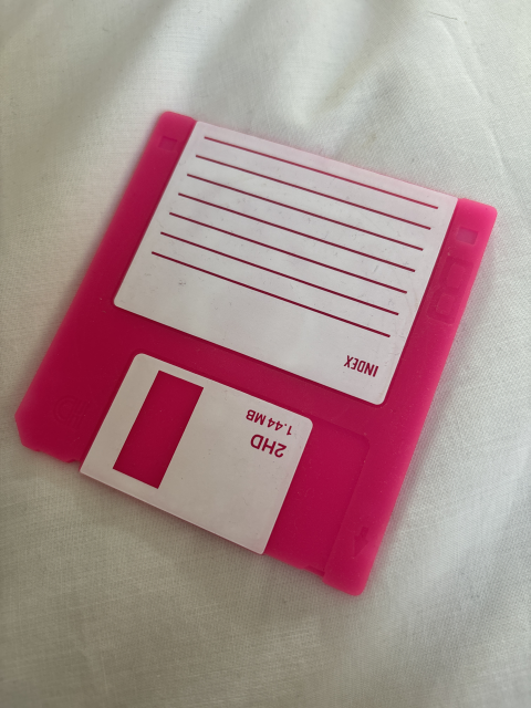 A silicone coaster realistically shaped and decorated like a 3.5” floppy disk.