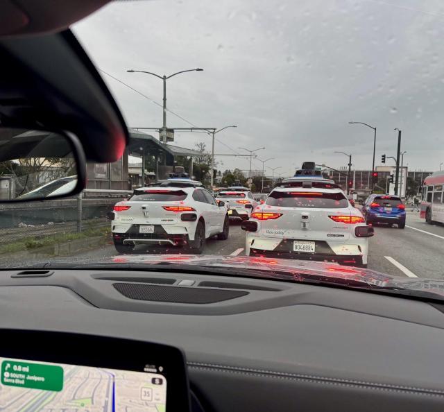 Three Waymos in front of my dashboard.