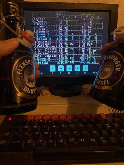 A BBC Master Computer running a (custom) Yahtzee game, in the foreground two bottles of beer. 