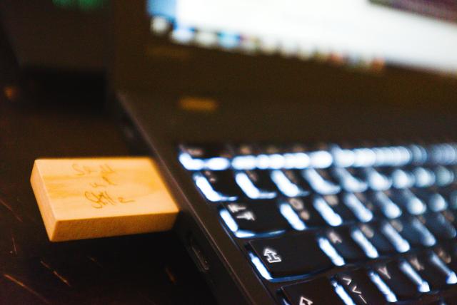 a wooden usb flash drive is inserted in a notebook
