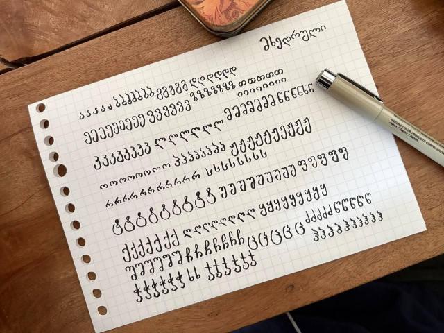 Georgian alphabet (Mkhedruli script) writing practice on graph paper, written with a Pigma brush pen