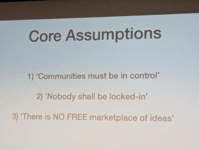 Slide titled "Core Assumptions" listing three points: 1) "Communities must be in control" 2) "Nobody shall be locked-in" 3) "There is NO FREE marketplace of ideas."