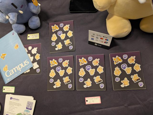 Mastodon table with several stacks of sticker sheets, and a sign for €4