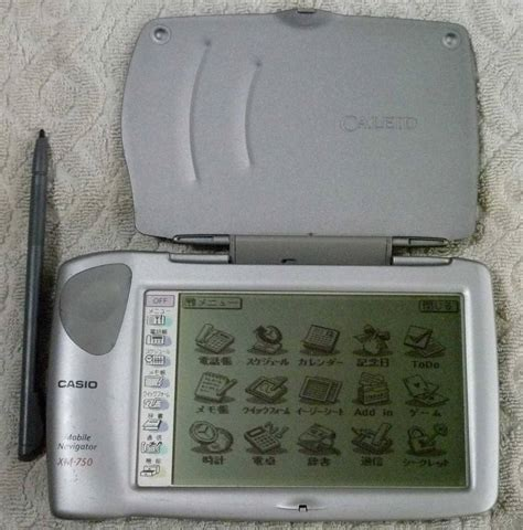A photograph of a landscape-mode touchscreen-based Japanese computer/organiser called Casio Mobile Navigator XM-750, showing three rows of application icons
