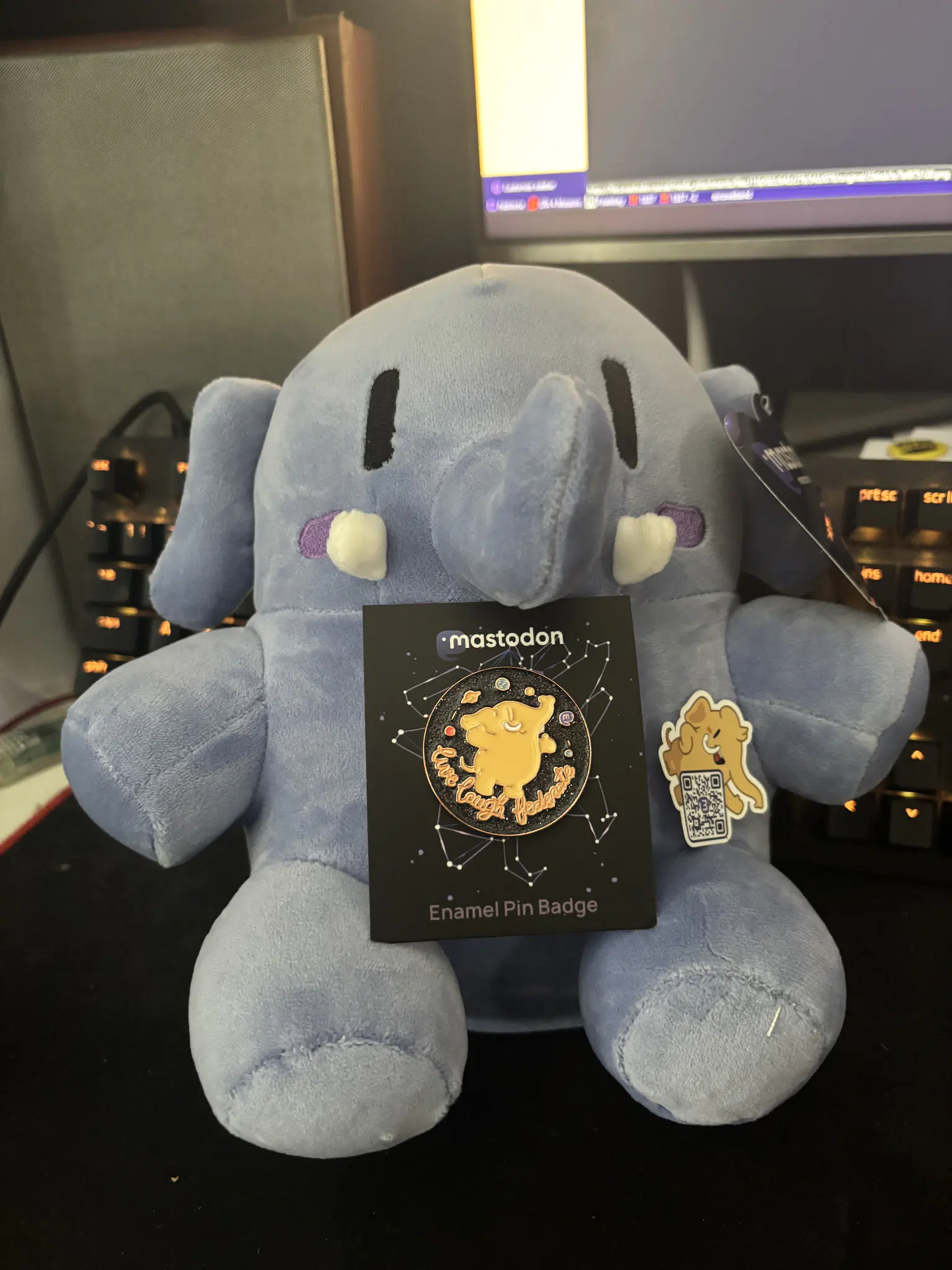 Blue Plushtodon holding 'Live Laugh Federate' pin and a mastodon picker with a QR code linking to joinmastodon.org