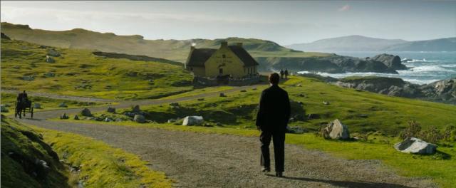 a man is walking down a path towards a pub on the shores of Ireland. There are no other buildings in view, there is only greenery, and rocks. A horse-drawn carriage is coming towards him in the distance. The pub is near the water.