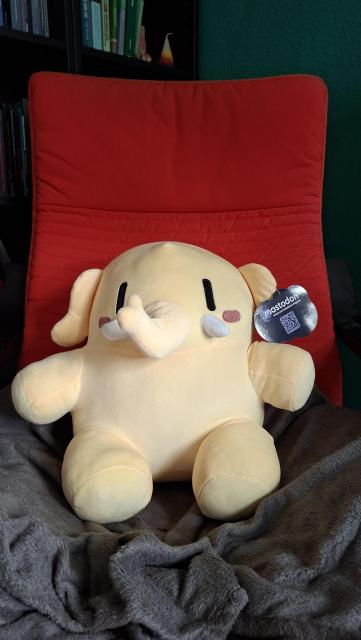 Das Bild zeigt ein Mastodon Plüschtier, dass auf einem Sessel sitzt.