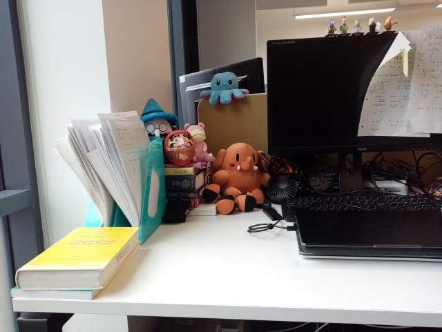 Small collection of plush toys next to a computer screen