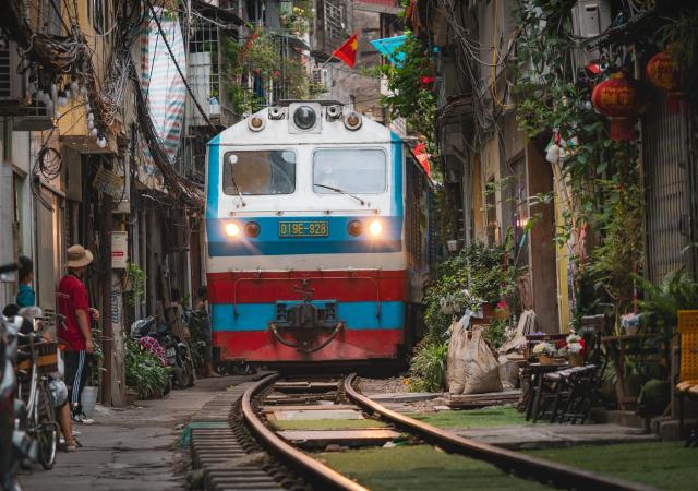 Train in very tight street with people watching 