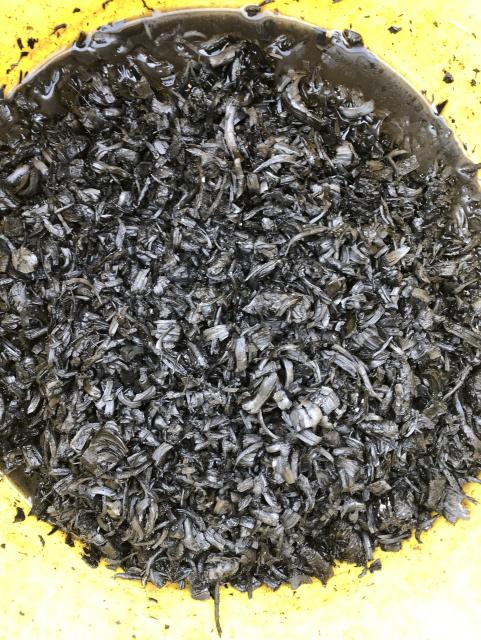 A trug with quenched charcoal - there us some water in the bottom of the trug, the liquid run off from a wormery was added to the charcoal to let the microbes colonise the charcoal. 
Some breaking up of the charcoal chips is still needed. 