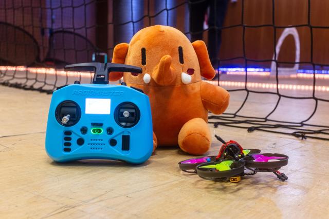 Plushtodon, avec un drone et sa télécommande, au milieu de la salle polyvalente de l'EPFL