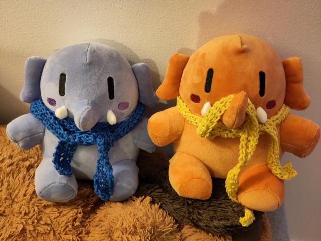 Photo de deux peluches mastodon avec des écharpes