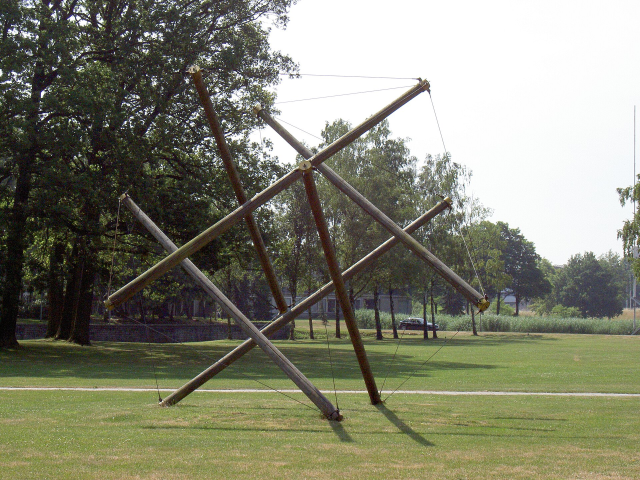 A photograph of the sculpture Het Ding, a large tensegrity icosahedron built from telephone poles and steel cables. Photograph in the public domain, from https://commons.wikimedia.org/wiki/File:Universiteit_Twente_Het_Ding_20050628.jpg