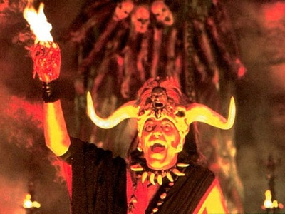 Still from Indiana Jones & The Temple of Doom.

Tantric Witch Doctor, ( wearing a head gear of horns, and adorned with skulls ) rips out a living human's heart out of his chest, and holds it up, as it bursts into flames.