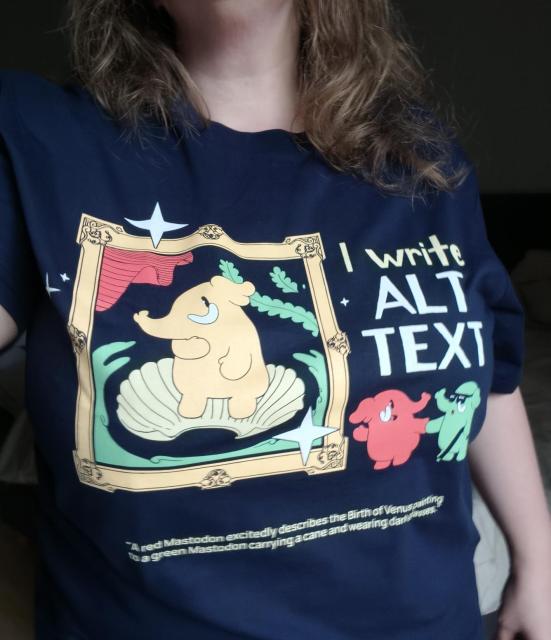Tragefoto vom neuen Mastodon-Tshirt.
Dunkelblaues T-Shirt mit Aufdruck

Eine große gelbe Mastodon-Figur befindet sich als Venus-Gemälde in einer Muschel, die von einem goldenen Rahmen umgeben ist. Rechts daneben stehen zwei kleine Mastodons wie im Museum vor dem großen Gemälde, die grüne Mastodon-Figur mit einem Stock und dunkler Brille, ein rotes Mastodon erklärt ihm das Bild. Oben rechts neben dem Gemälde steht der Text 'I write ALT TEXT'. 
Unten ist ein kleiner weißer Text: 'A red Mastodon excitedly describes the Birth of Venus painting to a green Mastodon carrying a cane and wearing dark glasses.'