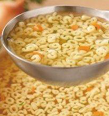 Close up of a soup laddle containing soup and number noodles.