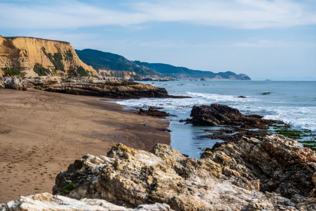 A rocky beach, with cliffs on one side and the sea on the other. [Fuji X-T5 / Sigma 17-40 1.8]