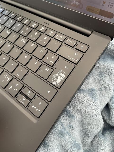 A notebook with custom prints (not stickers!) on its keys - the enter key has a German Dönermann artwork on it, as known from literally every Döner wrapping paper. The U and O keys have UwU and OwO on them.