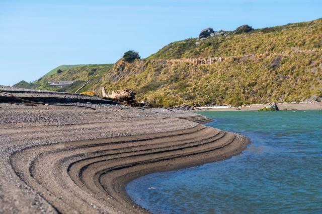 The sandy bank of a river shows multiple lines indicating a changing water level. [Fuji X-T5 / Sigma 17-40 1.8]