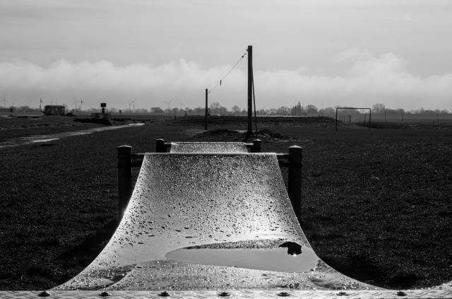 black and white picture of a wet jumping-thingamabob on a playground