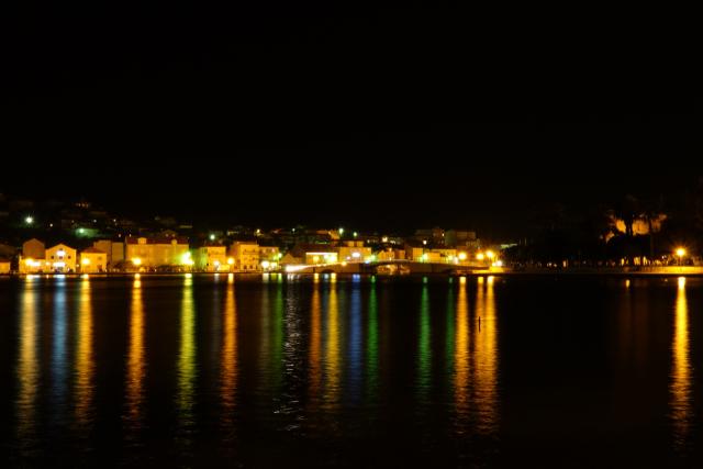 Reflet des lumières de la ville sur l'eau la nuit, ça ressemble à un codebarre