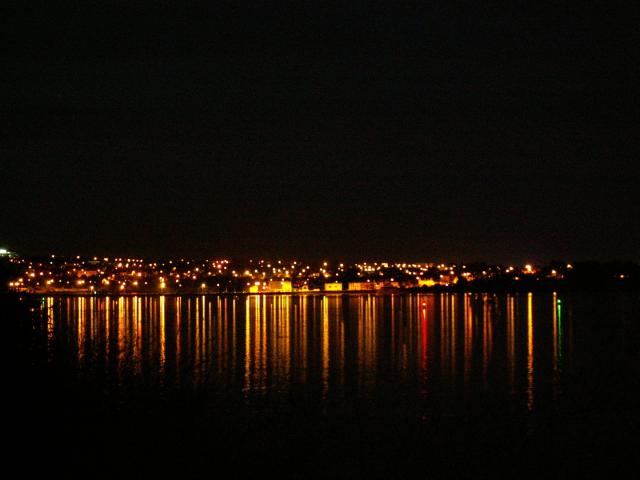 Reflet des lumières de la ville sur l'eau la nuit, ça ressemble à un codebarre