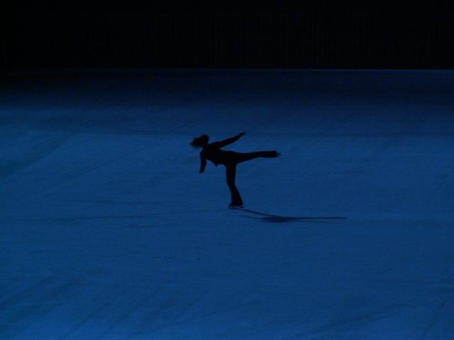 La silhouette d'une patineuse la nuit sur la glace