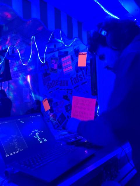 Picture of someone livecoding lit with a darklight garland