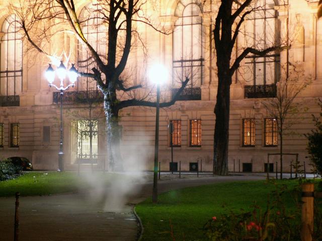 Paris la nuit dans les beaux quartier, un nuage de buée ou de fumée sort du sol, comme un fantôme