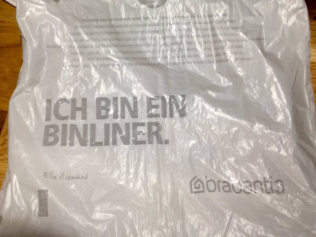 a large plastic bag on which is printed, "Ich bin ein bin liner."