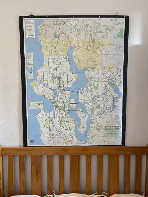 The MEGAMAP pinned to black foamcore hanging above and behind the bench in our entryway.