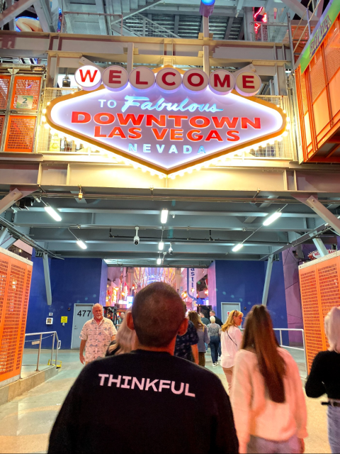 Photo of my back with a black Thinkful sweater on in front of the Downtown Las Vegas sign. The sign says "Welcome to Fabulous Downtown Las Vegas Nevada".