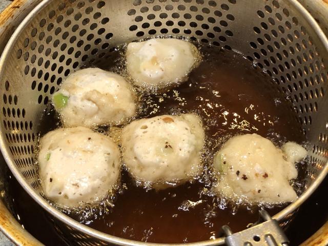 Apple dough balls (olliebollen) in a deep frier.