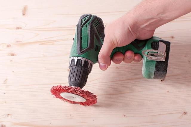 Cordless "drill" (actually more a screwdriver) with a reddish nylon brush for paint removal