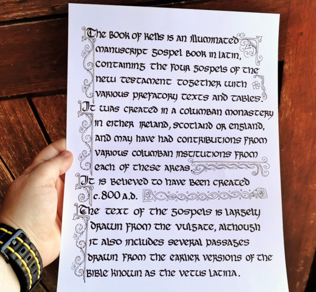 An A4 white page of paper being held by my hand in front of a wooden door. The page is a section of calligraphy in insular uncial script that is roughly illustrated with some swirls and sketchy knotwork, and reads:

The Book of Kells is an illuminated manuscript Gospel book in Latin, containing the four Gospels of the New Testament together with various prefatory texts and tables. It was created in a Columban monastery in either Ireland, Scotland or England, and may have had contributions from various Columban institutions from each of these areas. It is believed to have been created c. 800 AD. The text of the Gospels is largely drawn from the Vulgate, although it also includes several passages drawn from the earlier versions of the Bible known as the Vetus Latina. 