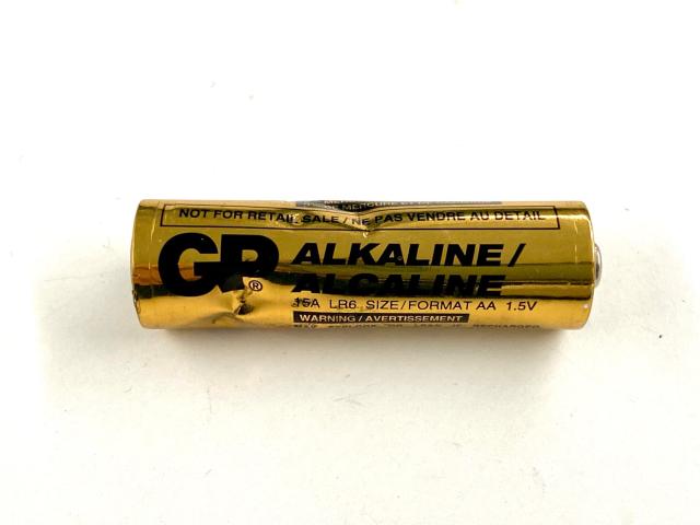 AA battery with visible dents all around it