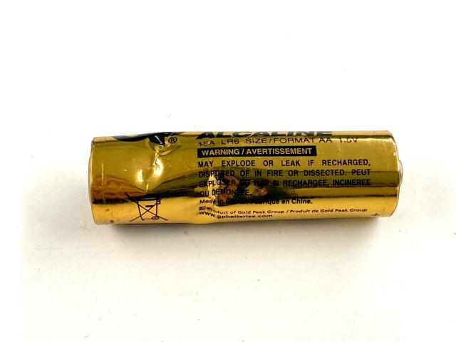 AA battery with visible dents all around it
